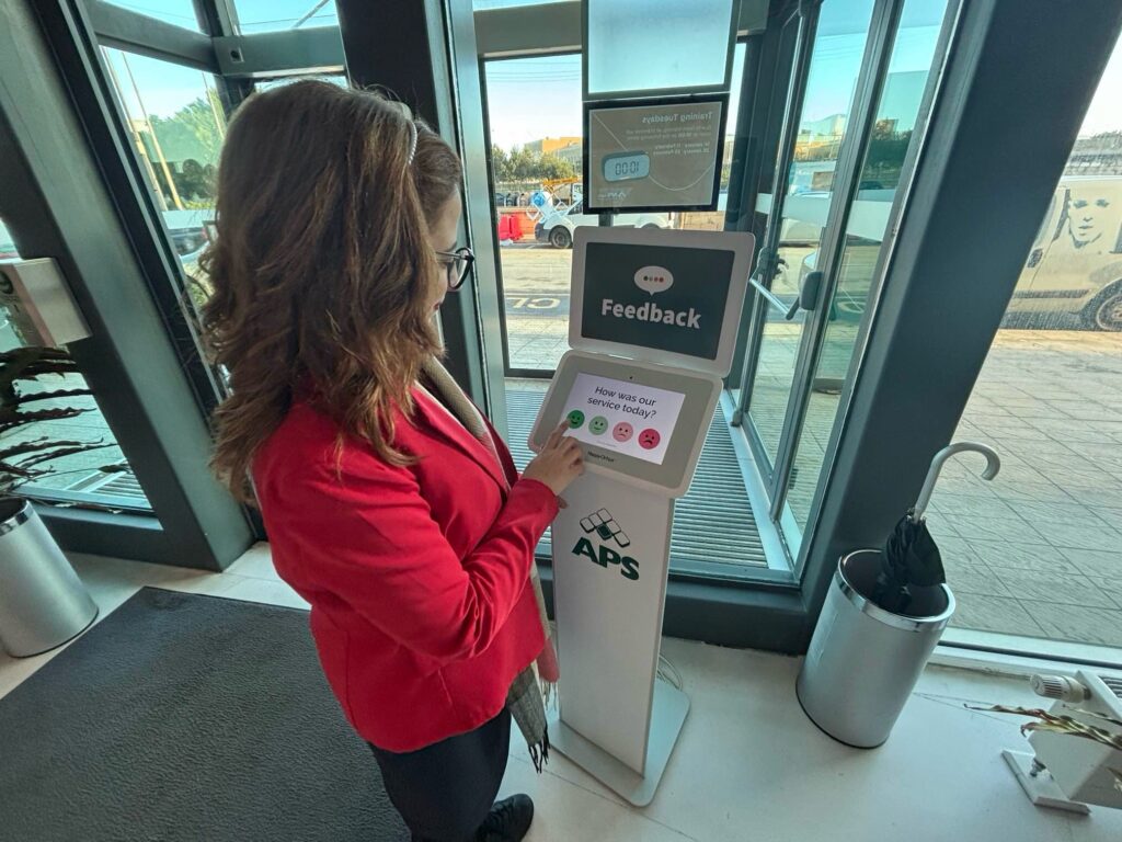 Customer leaving feedback with Smiley Touch device at APS bank